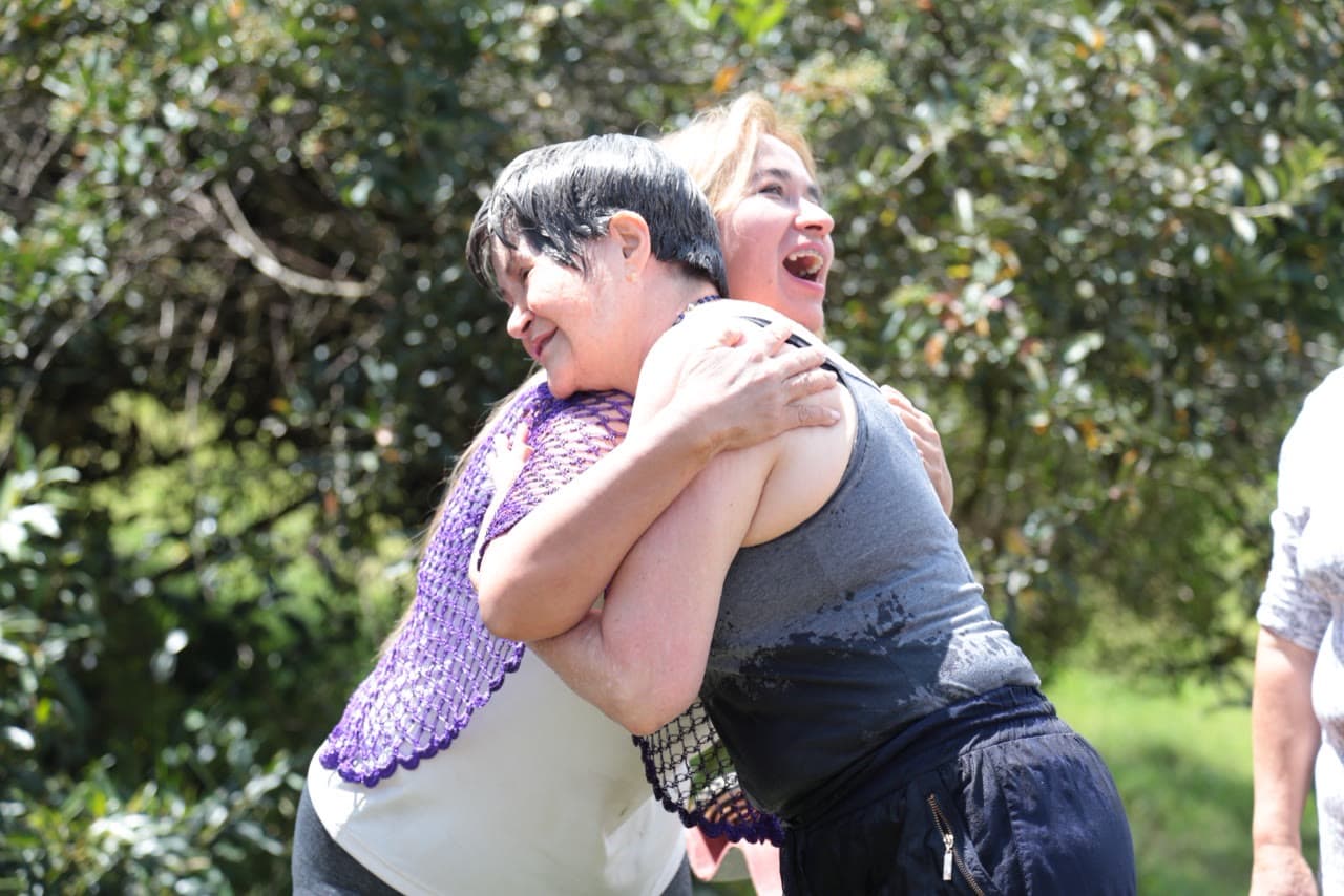Dos participantes abrazándose entre risas