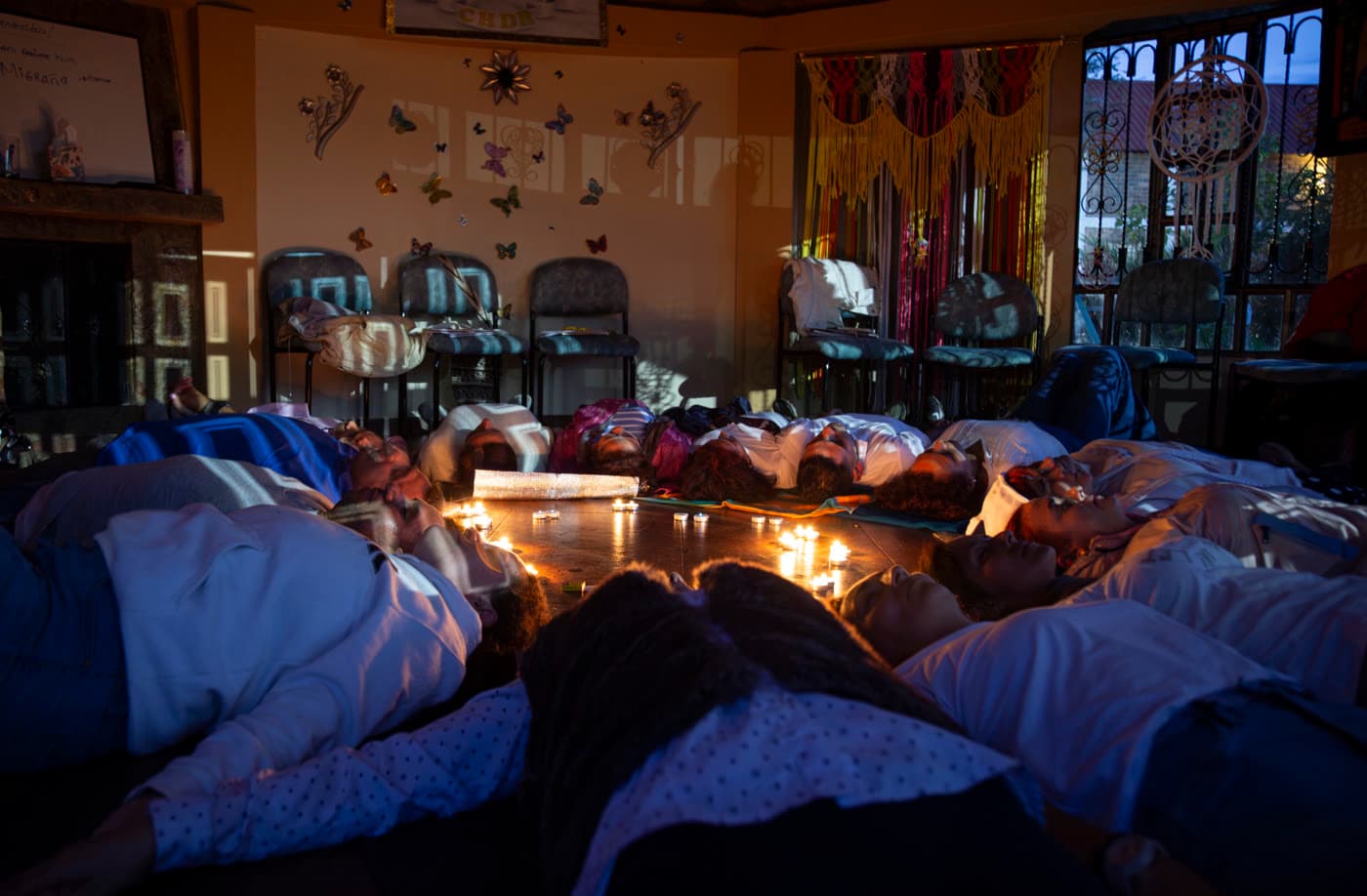 Personas acostadas en círculo alrededor de velas encendidas