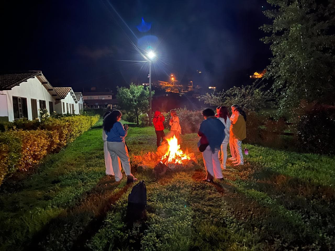 Participantes alrededor de una fogata de noche
